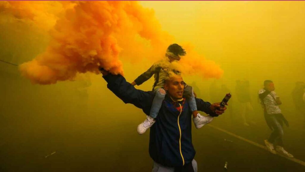 Club America fans are engulfed in bright yellow smoke